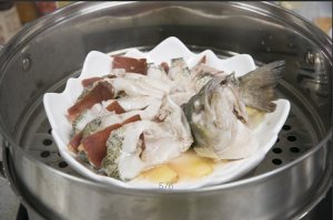 將鱸魚成花狀擺好，將火腿切片放入各縫隙中，放入鍋中隔水蒸12分鐘拿出，撒上蔥花即可。