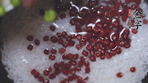 將炒好的食材和大米、紅豆一起放進(jìn)電飯鍋煮。