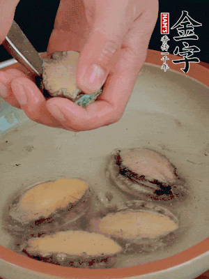 鮑魚加鹽、清水浸泡，用勺子挖出鮑魚肉。