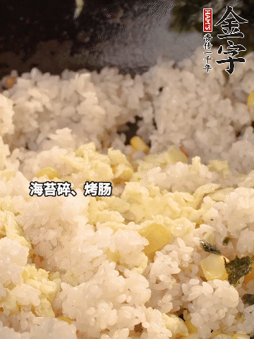 剩米飯下鍋炒散，依次下玉米粒、雞蛋、烤腸、海苔碎翻炒均勻。