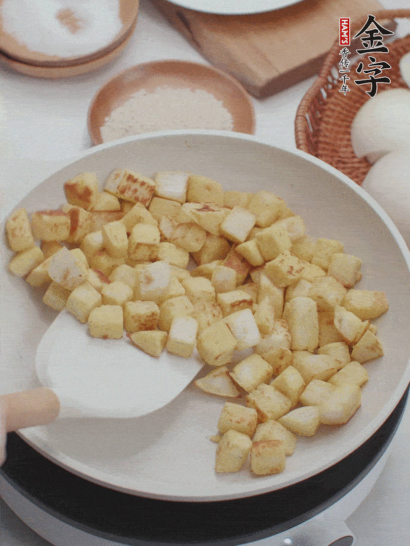 起鍋熱油，倒入饅頭丁，小火煎至蛋液凝固定型再翻面，饅頭丁部煎至金黃時盛起待用。