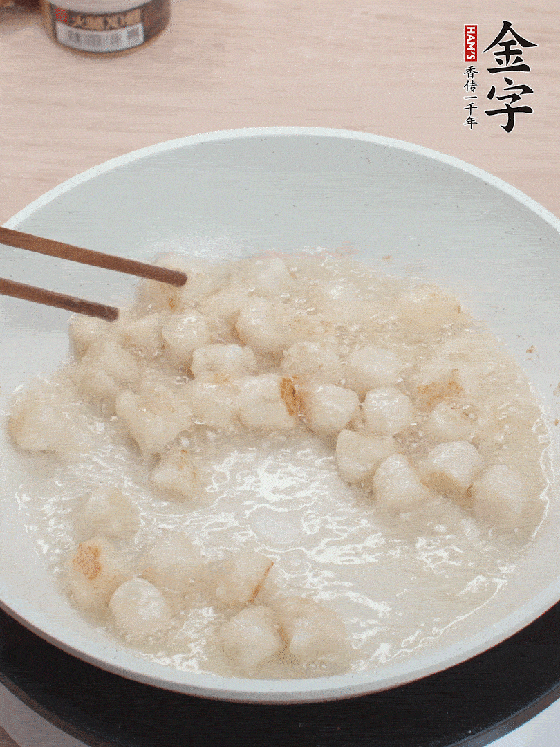 油溫4成熱，鮮貝蘸干淀粉下鍋煎，一面微黃后翻面。