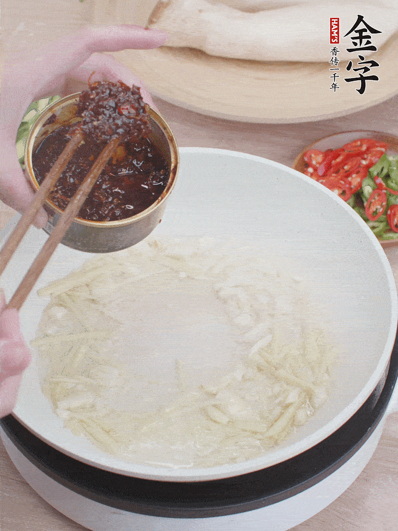 起鍋熱油，姜蒜、金字火腿干貝醬煸香。
