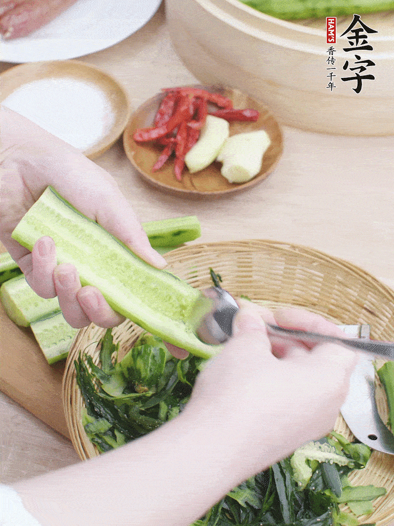 黃瓜削皮，對(duì)半切開，勺子挖去內(nèi)瓤，斜刀切片。青蒜斜刀切段。