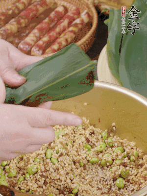 粽葉往下折，完全蓋住，兩側(cè)捏緊。