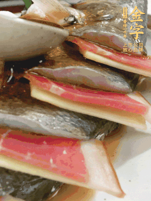 魚肚中塞蔥結(jié)、火腿片，魚身上碼放姜片、火腿片，倒入混合的料汁。
