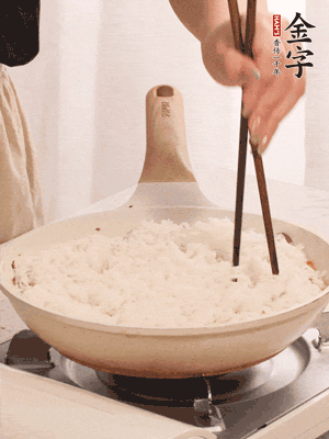 把瀝干水分的米飯均勻鋪在上面，筷子戳幾個洞，以便透氣，轉(zhuǎn)小火蓋上蓋子燜至水分收干，大概10分鐘。