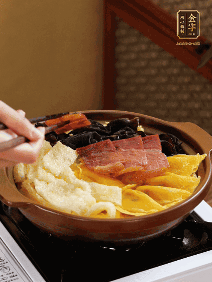 砂鍋底部鋪上娃娃菜，依次擺上肉皮、蛋餃、黑木耳、火腿
